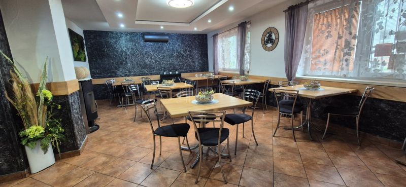 A dining area in commercial premises with tables and chairs, a floor with a wooden decor.