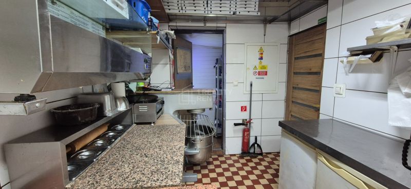A kitchen in commercial premises with a marble countertop and tiled floor.