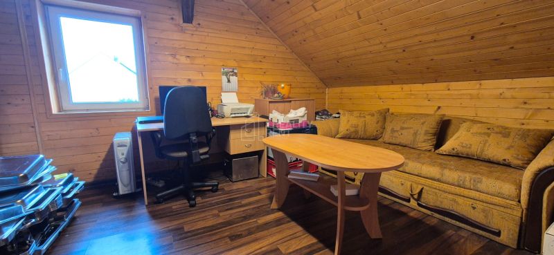 An interior with a work corner, wooden paneling, and a floor with a wood decor.