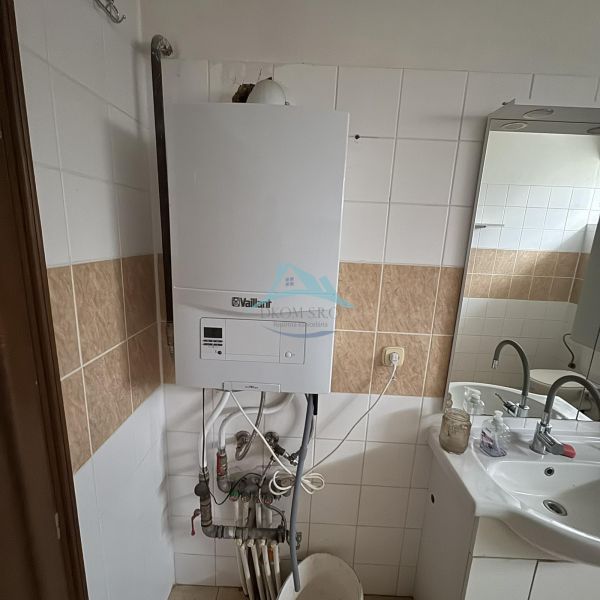 Bathroom with a gas boiler and a sink in a family house.