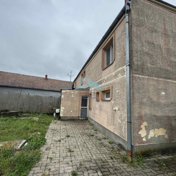 A family house in Veľká Čalomija with an older facade and a paved courtyard.