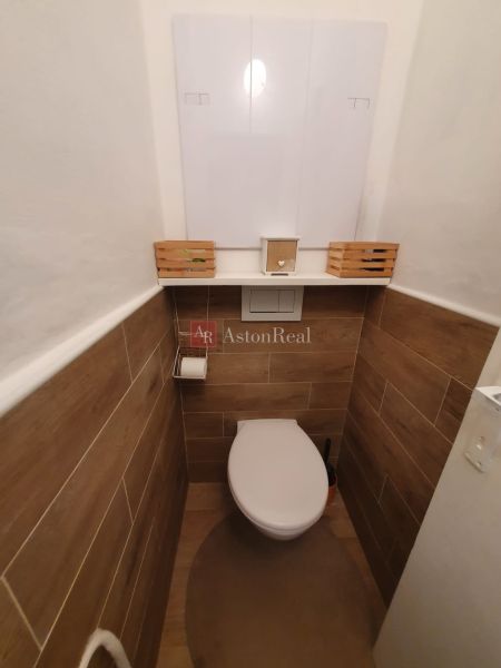 A toilet with wood-effect tiles in a 3-room apartment.