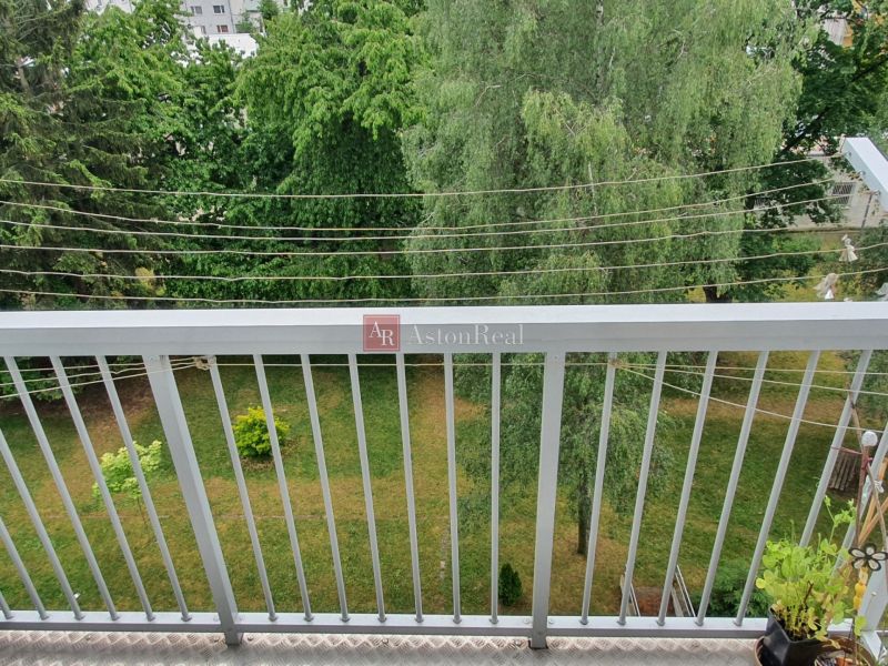 A balcony in a 3-room apartment on Nábrežná Street in Trenčín with a view of greenery.