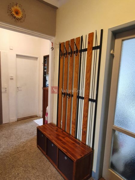 A hallway of a 3-room apartment with a coat rack and practical storage space.