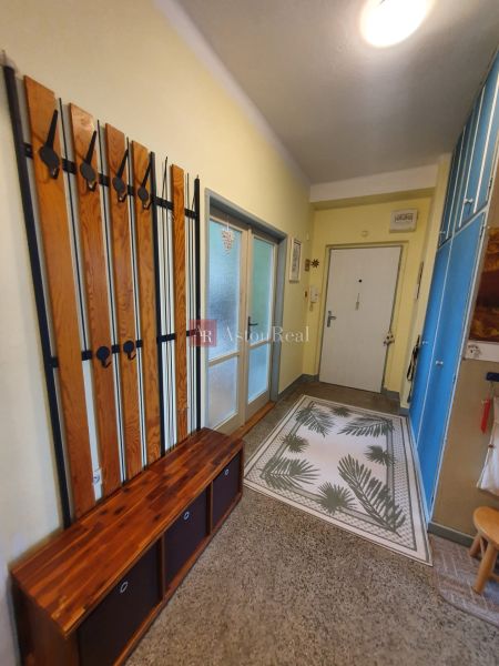 A hallway in a 3-room apartment with flooring and storage spaces.