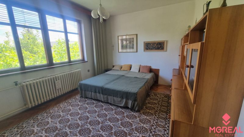 Bedroom in a family house with carpet decor and a large bed.