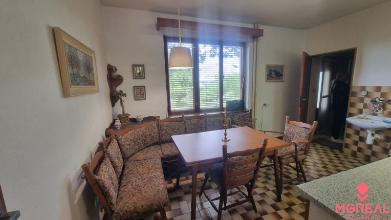Dining area in a family house with windows and checkered floor.
