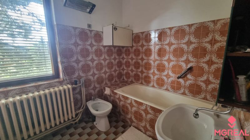 Bathroom with tiles and a bathtub in a family house.
