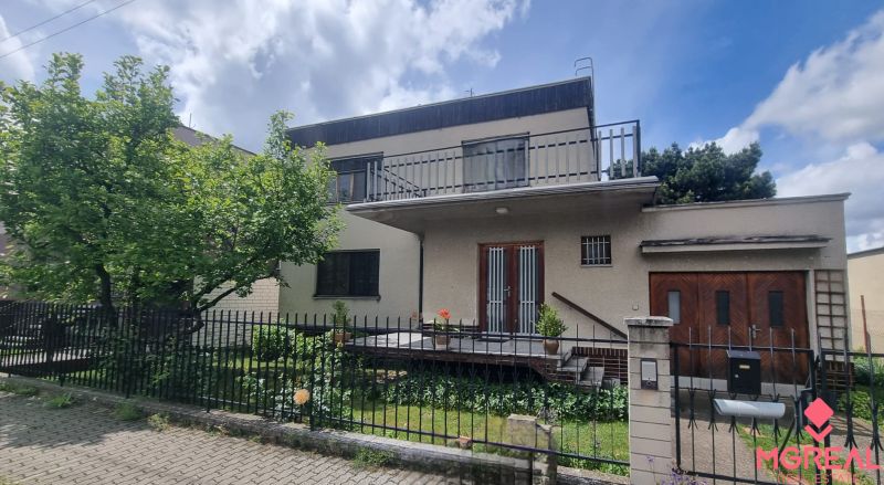 A family house in Leopoldov with a flat roof, a two-story terrace, and a green garden.