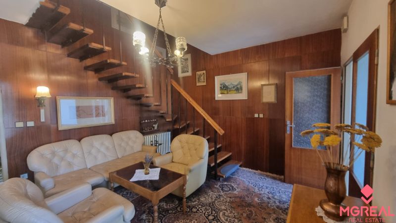Interior of a family house with wooden wall paneling and comfortable leather seating.