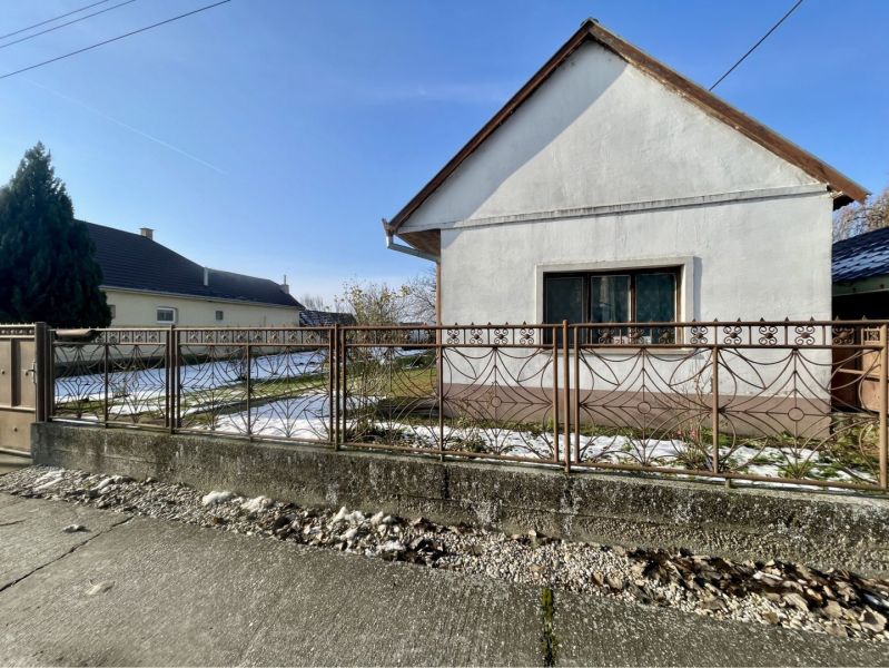A family house in Vrakúňa with a white facade, lawn, and decorative fence.