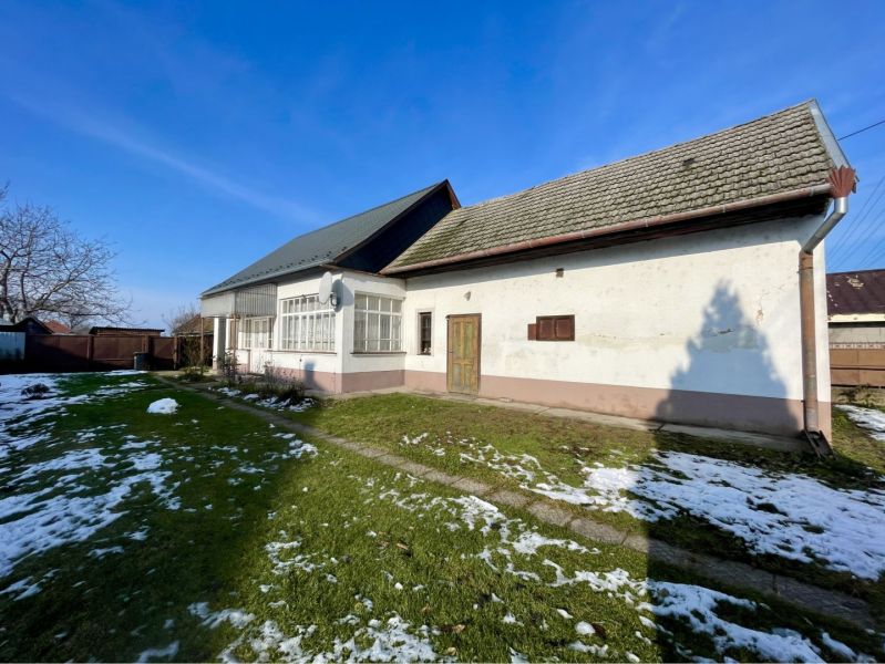 A family house on a plot in the village of Vrakúň, a snow-covered garden around the house.