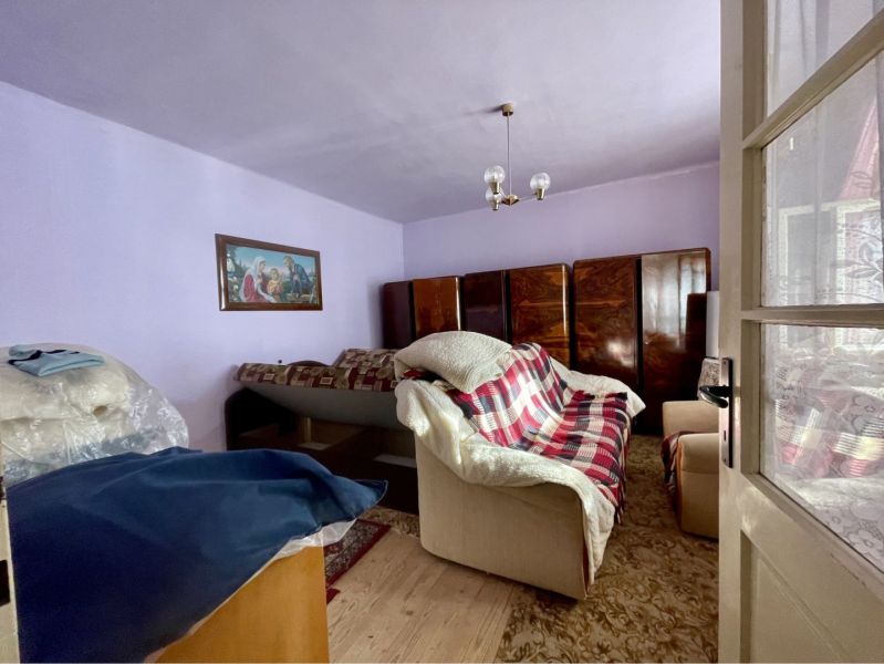 Living room with a sofa, cabinets, and a painting, floor with wood decor, Property - living.