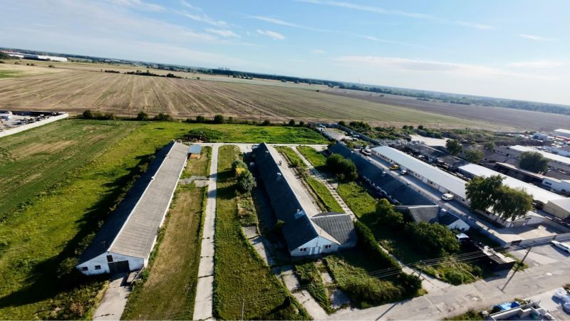 Production premises in Amadeho Kračany in Kostolné Kračany surrounded by agricultural fields.
