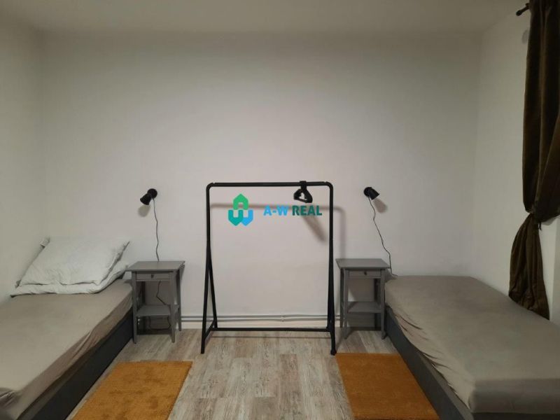 Two beds with nightstands and a wooden floor decor in a family house.