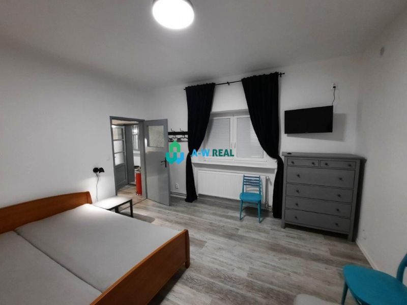 Bedroom in a family house with a wooden decor floor, bed, and dresser.