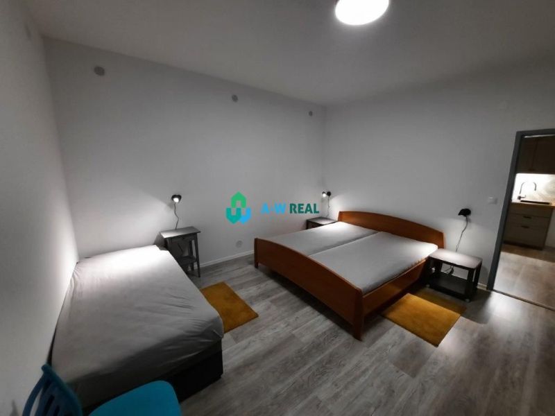 A bedroom in a family house with beds and a wooden decor floor.