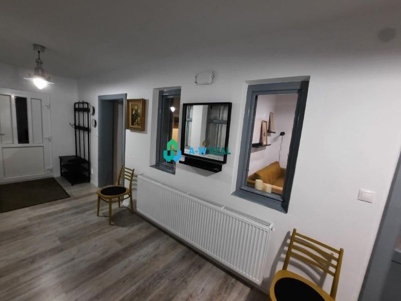 Interior of a family house with a wooden decor floor, white walls, and furniture.