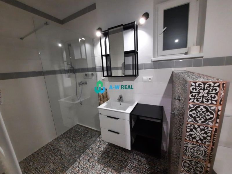 A bathroom in a family house with decorative tiles and a shower corner.