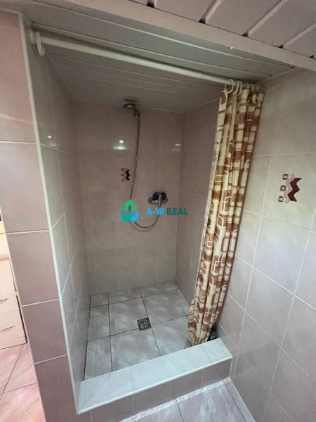 Shower corner with tiles and curtain in a family house.