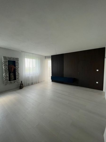 Living room with wood-patterned flooring, curtains, and a decorative mirror in a 3-room apartment.