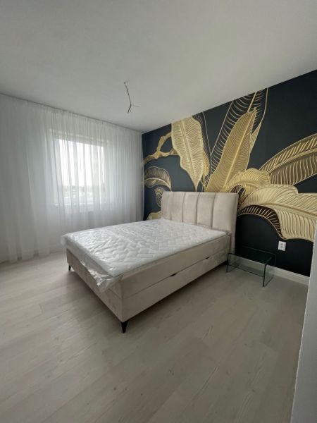 Bedroom in a 3-room apartment with a decorative wall and a wooden decor floor.