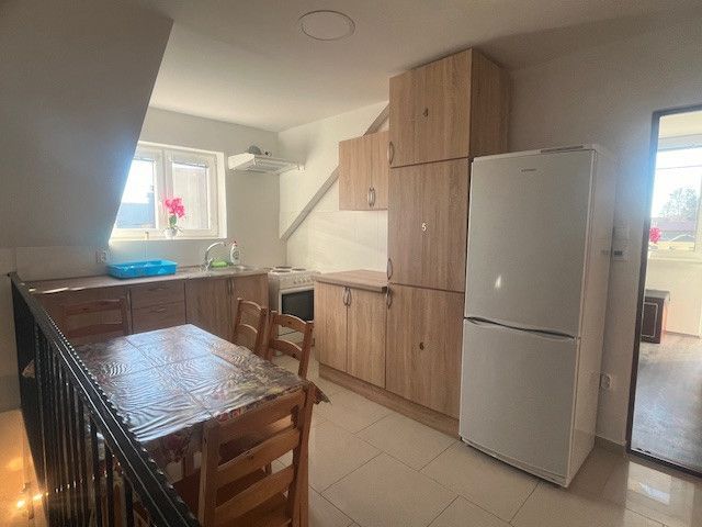 A kitchen in a building with wooden decor furniture and a dining table.