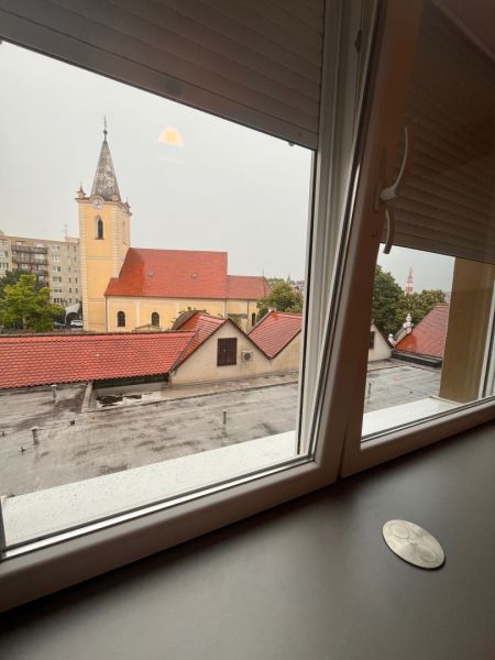 A view from the window of a one-room apartment to the church in Dunajská Streda on a cloudy day.