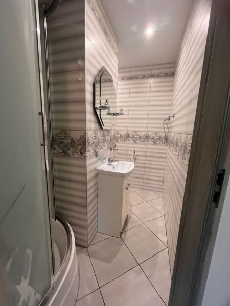 Bathroom with a bathtub, sink, and mirror in a studio apartment.