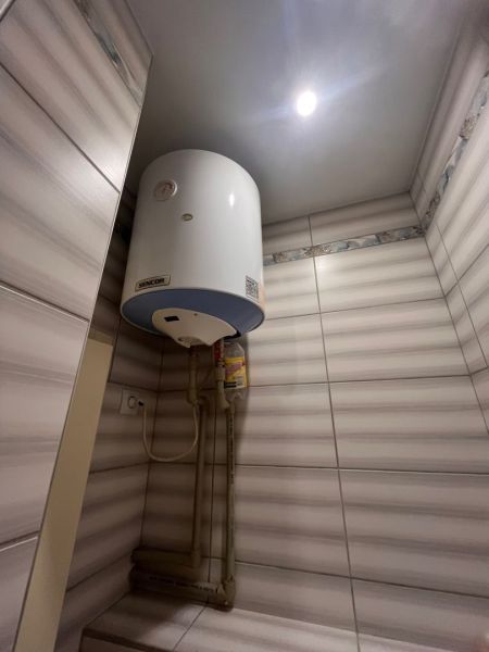Water heating in the bathroom: boiler and tiles in a studio apartment.