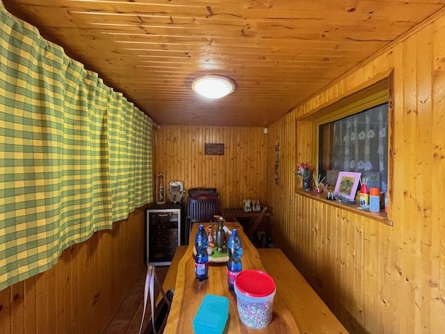 Interior of a family house with wooden paneling, a table, and decorative items.