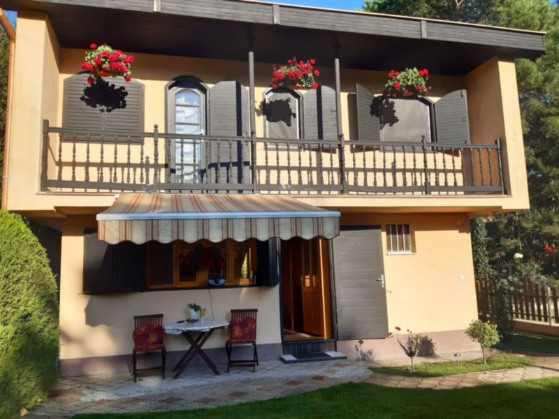 A family house in Gabčíkovo with a balcony, an awning, and flowers on the windows.