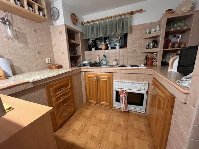 A kitchen in a family house with a wooden decor floor and preserved coziness.