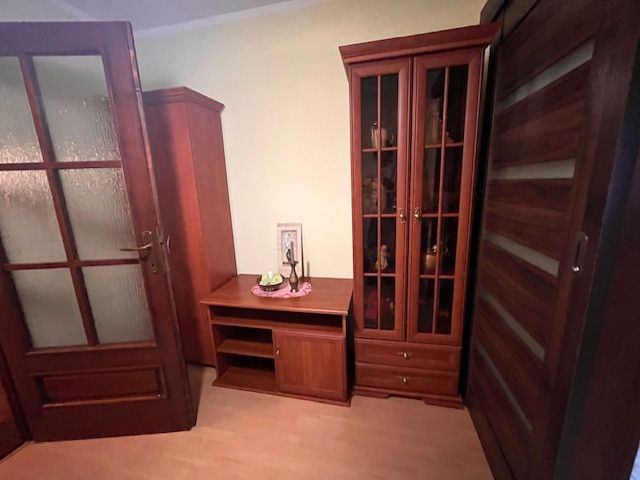 Dark wood furniture, wood-patterned flooring in the interior of a family house.