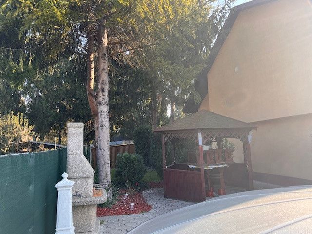 A family house in Gabčíkovo with a gazebo and trees in the garden.