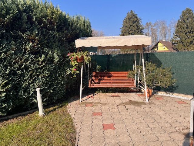 The garden of a family house in Gabčíkovo with a swing, built into a tiled terrace.