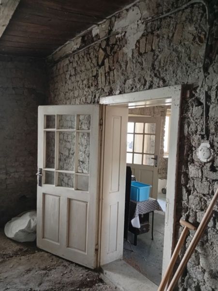 Old wooden doors and bare walls in the interior of a family house.