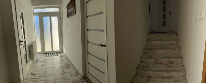 Interior of a family house with a hallway, staircase, and floor with wooden decor.