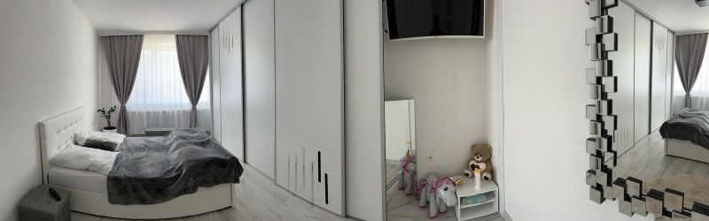 Bedroom in a family house with a bed, wardrobe, toys, and a decorative mirror.