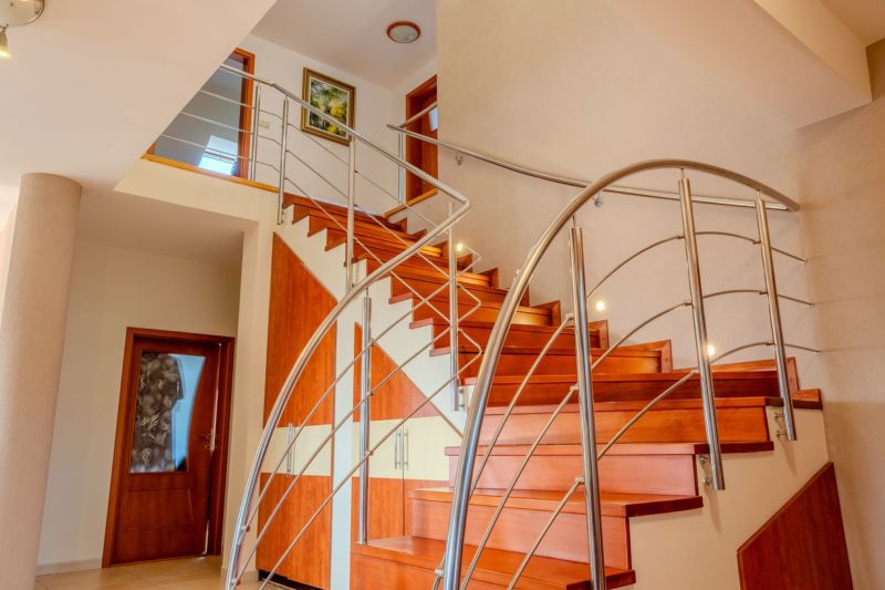 A staircase in a family house with a wooden decor floor and metal railing.