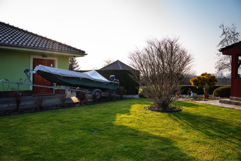 A garden at a family house in Dolný Bar with a boat on a trailer and a well-maintained lawn.