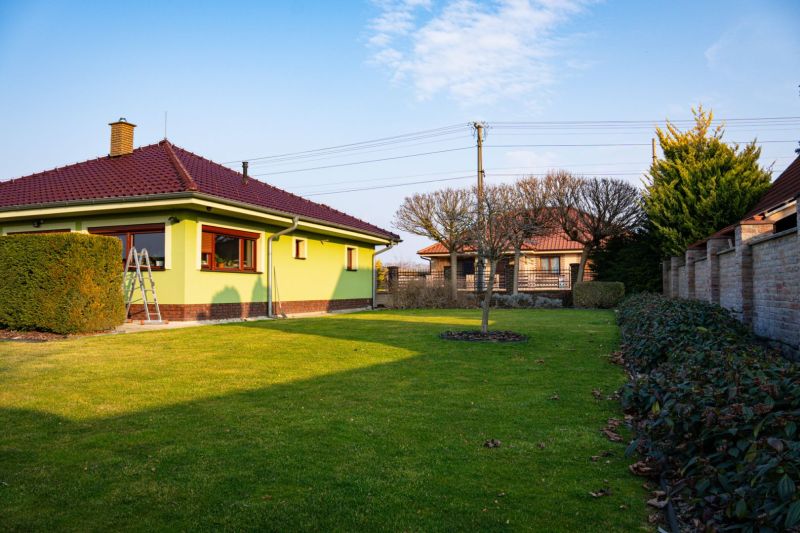 A family house in Dolný Bar with a well-maintained garden, trees, and shrubs on Dolný Bar street.