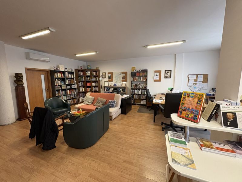 A library with comfortable seating and a wooden decor floor in a 3-room apartment.