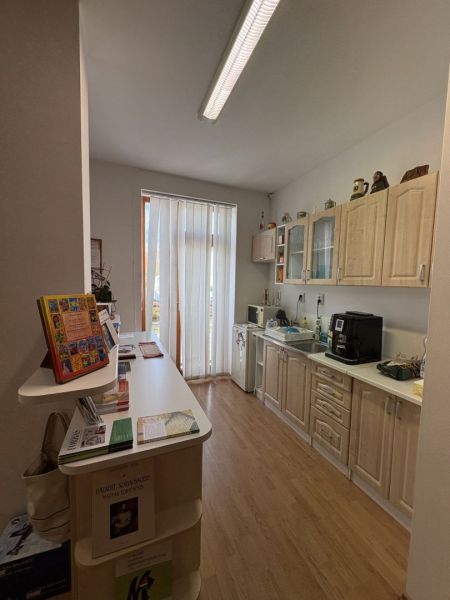 A kitchen with a wooden decor floor and a kitchen unit in a 3-room apartment.