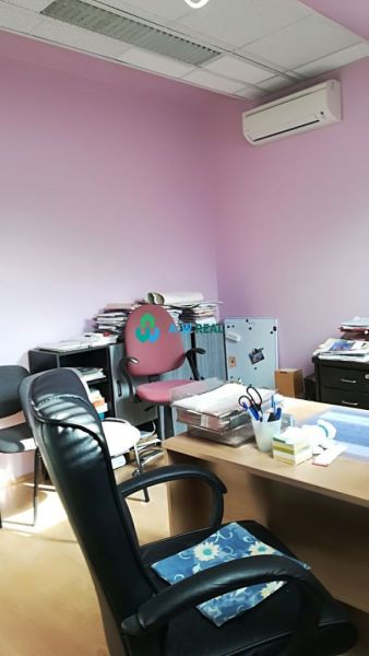 Offices with purple walls, a desk, and a wood-patterned floor.