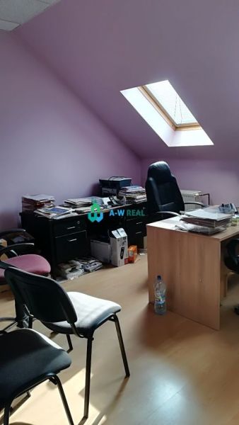 Offices with wood-patterned flooring and a skylight, furnished with furniture and chairs.
