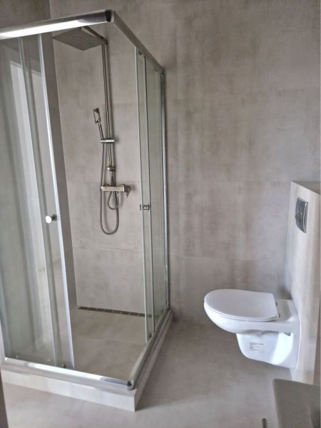 A bathroom in a 3-room apartment with a modern shower and a wall-mounted toilet.