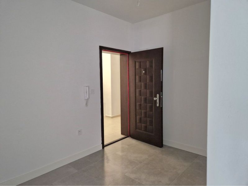 Entrance hallway in a 3-room apartment with tiled floors and security doors.