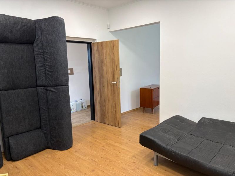 The room has black furniture and a floor with a wood decor, suitable for warehouses and halls.