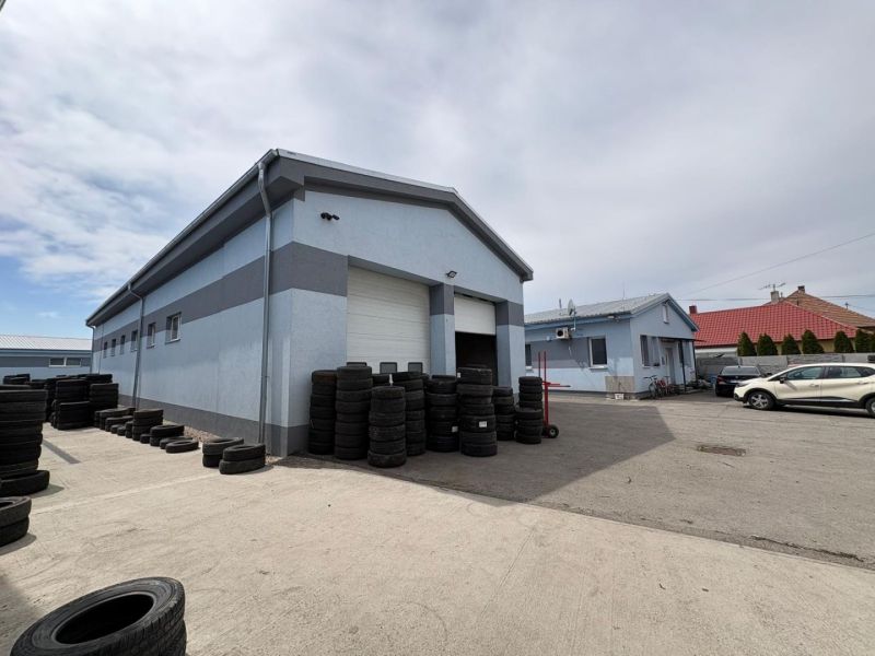 Warehouses and halls in Orechová Potôň with tires and cars in the yard.